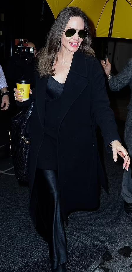 Angelina Jolie in long black coat with black top handle bag in New York on  November 2 ~ I want her style - What celebrities wore and where to buy it.  Celebrity Style